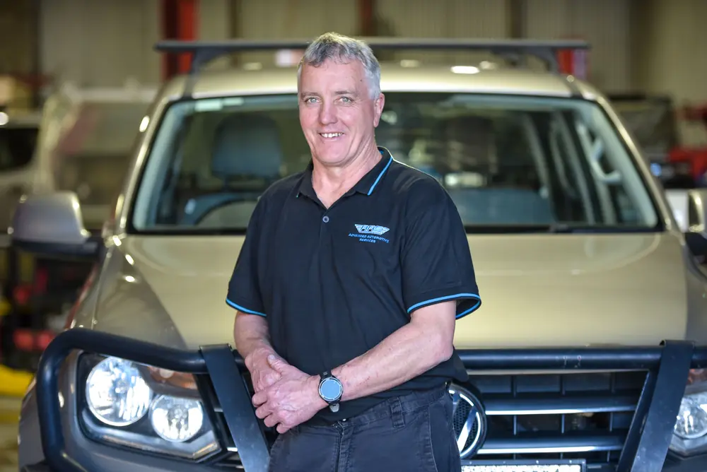 Mechanic standing with a four-wheel drive
